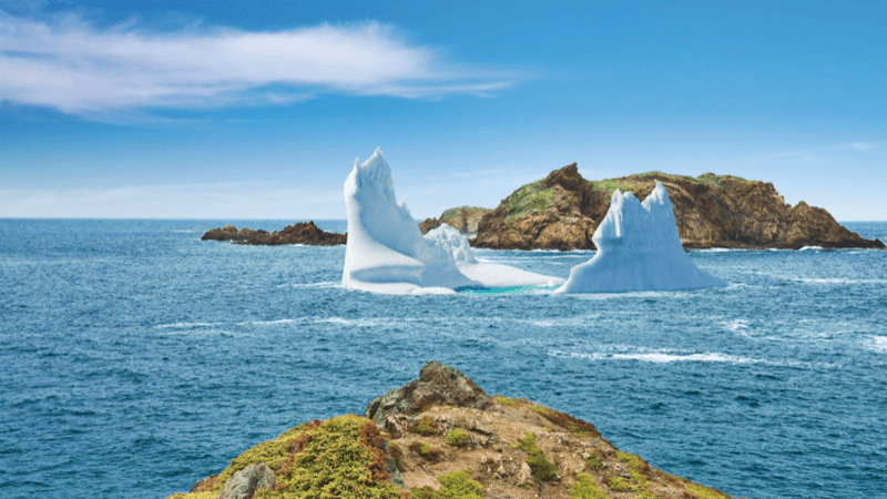 A massive iceberg is sitting in front of an island just off the coastline in Twillingate.