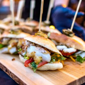 Delicious sandwiches are on a platter at a food festival.