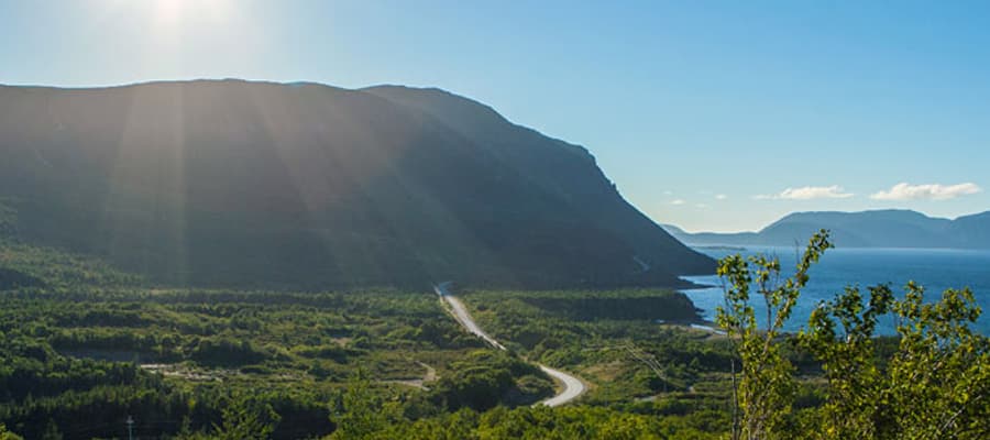 A paved, winding road leads along the coastline.