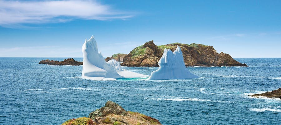 A massive iceberg is sitting in front of an island just off the coastline in Twillingate.