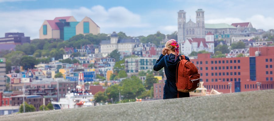 A girl with colourful hair is walking in the colourful city of St. John’s. 