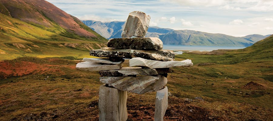 An inukshuk standing tall among the mountains in Labrador.