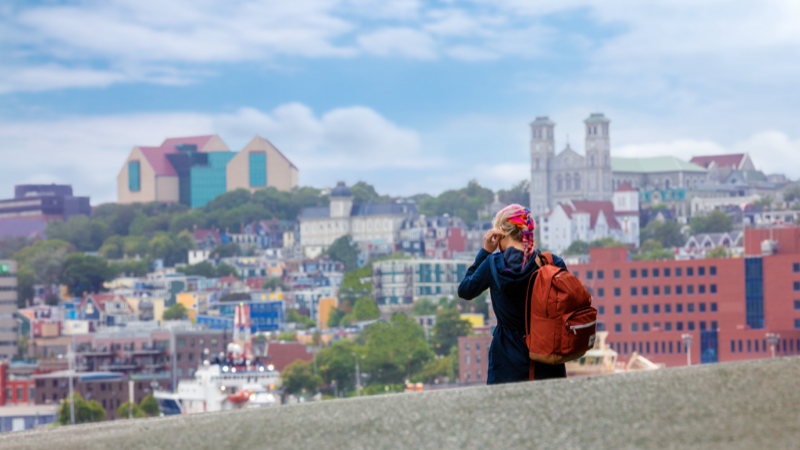 A girl with colourful hair is walking in the colourful city of St. John’s.