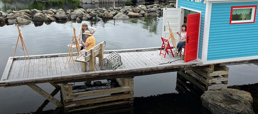 Travellers are painting on the dock at the harbour in New Perlican.