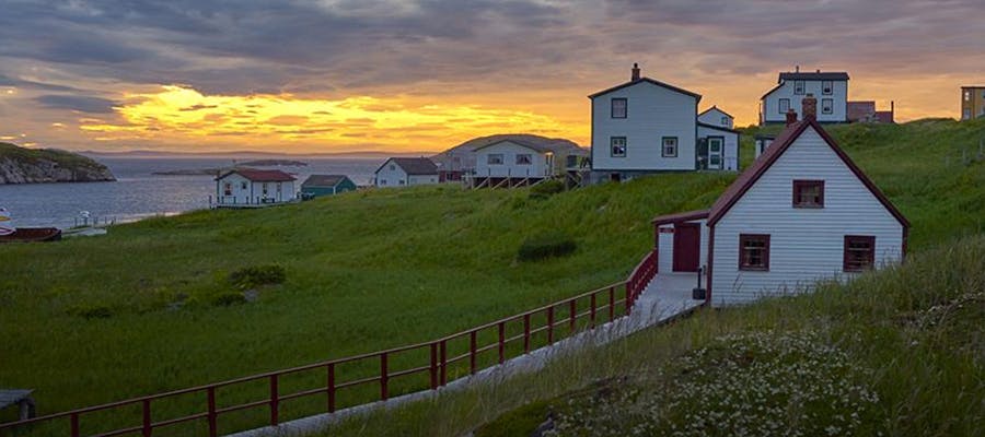 Houses in Battle Harbour with the ocean and a beautiful sunset in the background.