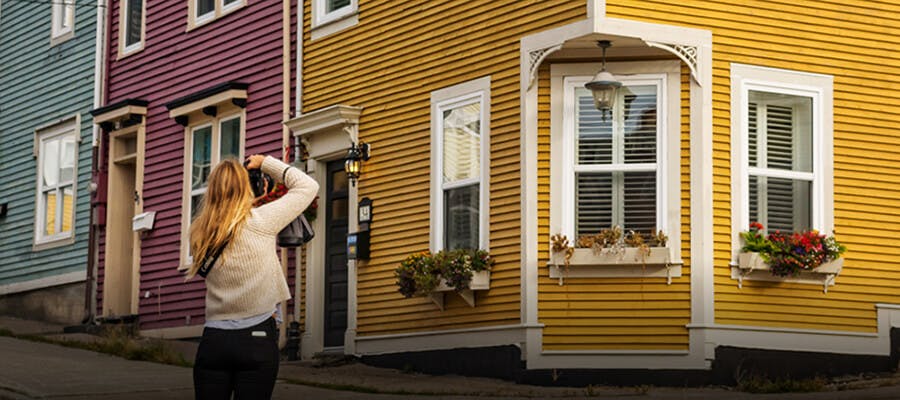 A traveller photographing the colourful houses in St. John’s.